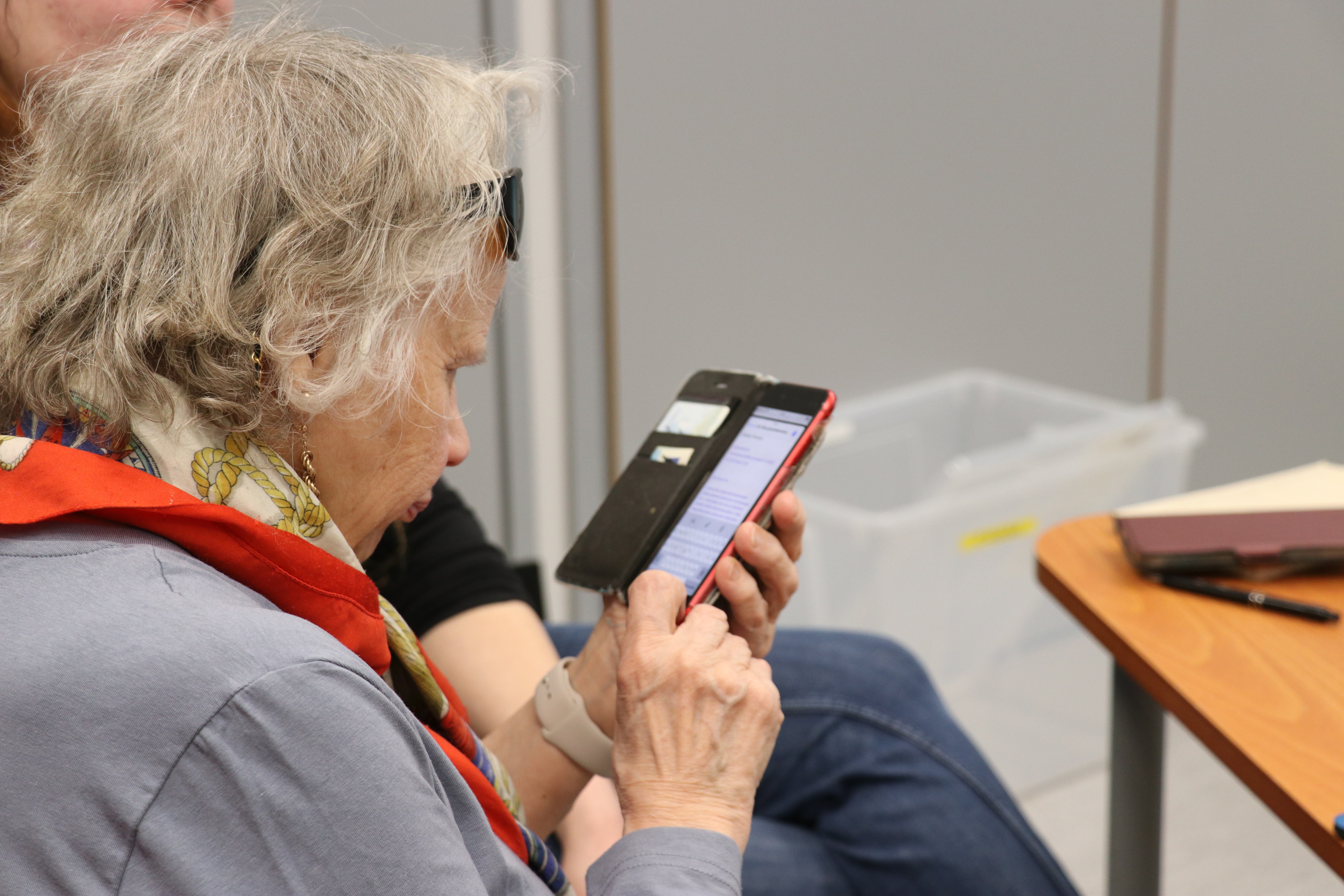 Henkilö tutkii puhelinta.